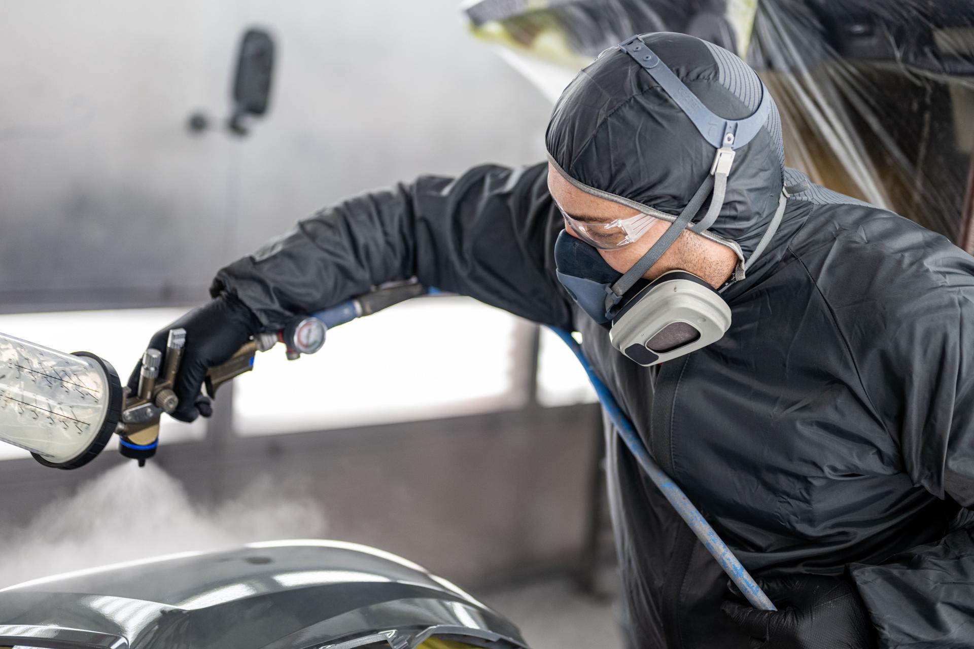 Caucasian Male Spray Painting Car Parts in Workshop